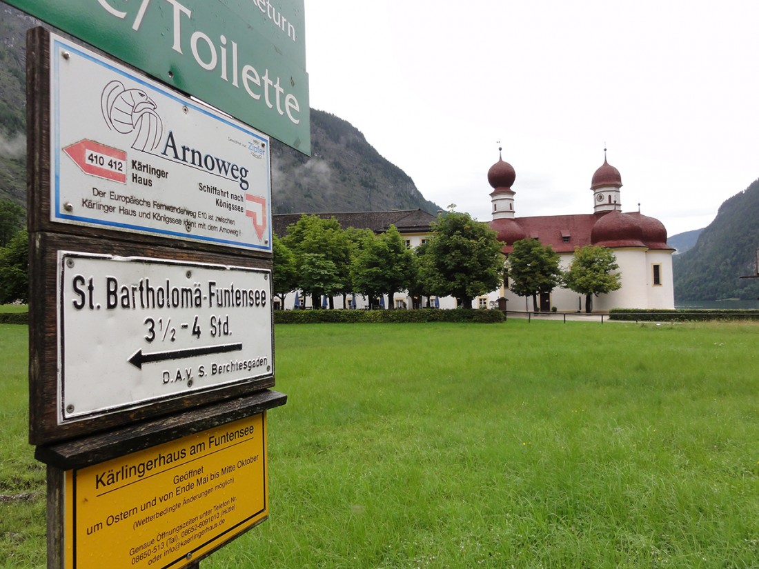 Arnoweg: Die Kirche von St. Bartholomä am Königssee mit Wegweiser